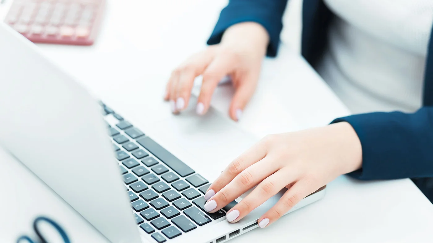 Hands working on a laptop